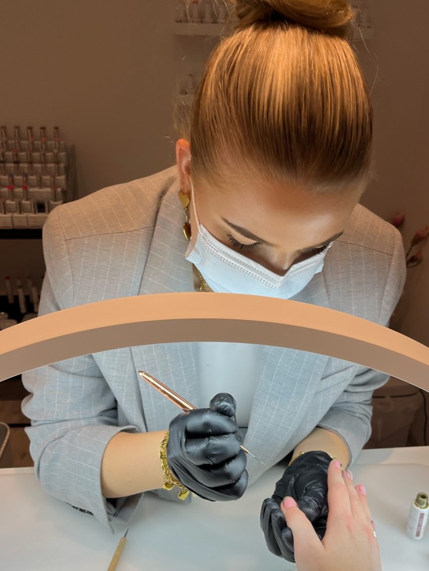 Manon aan het werk aan haar tafel, met mondkapje en handschoenen