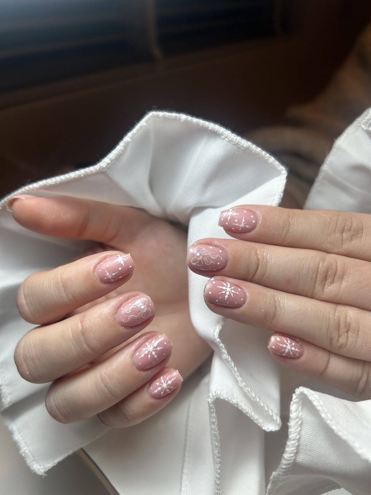 Nude nagels met witte sneeuwvlokjes