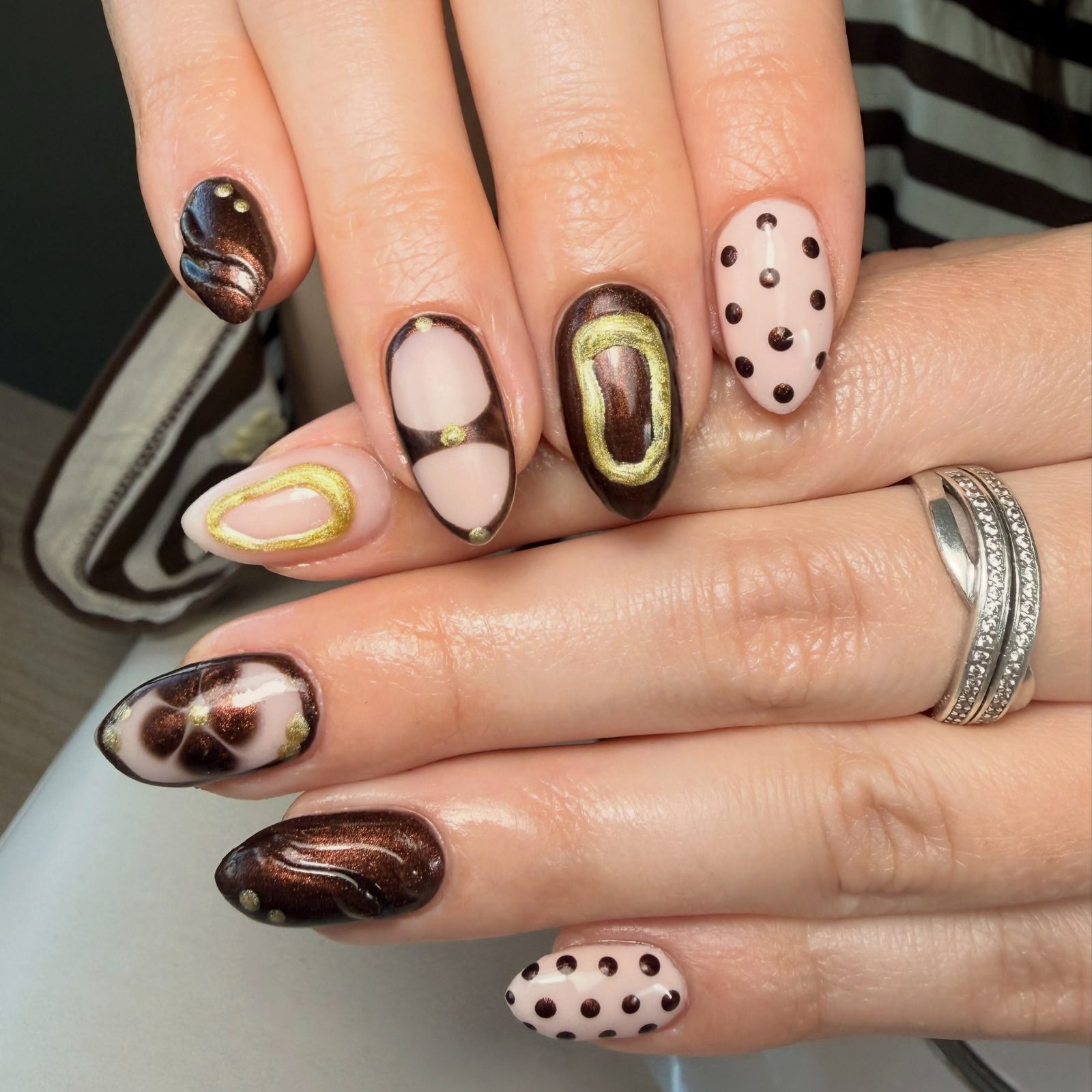 Nail art in bruin en nude met gouden contouren, stipjes en marmer
