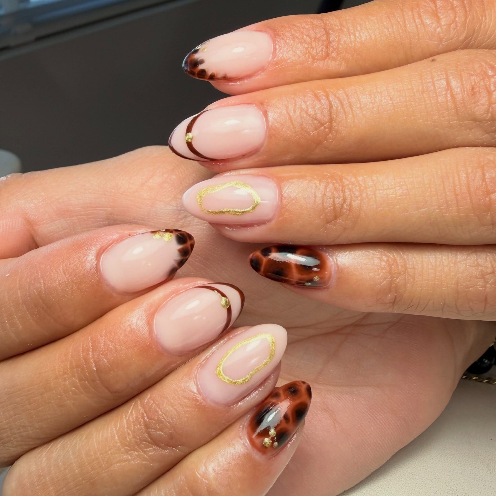 Chocoladebruine French tips met een gouden lijn en schildpadprint